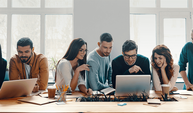 Group of employees working over a laptop